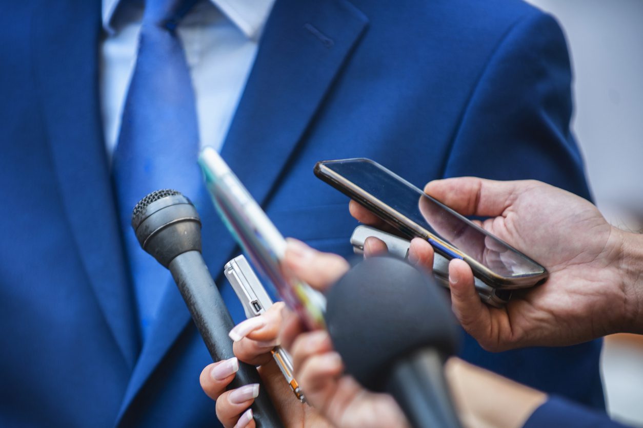 Cropped Hands Of Journalists Interviewing Businessman In City